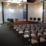 Oak Lawn Cemetery and Arboretum chair and pews in front of indoor community mausoleum crypts