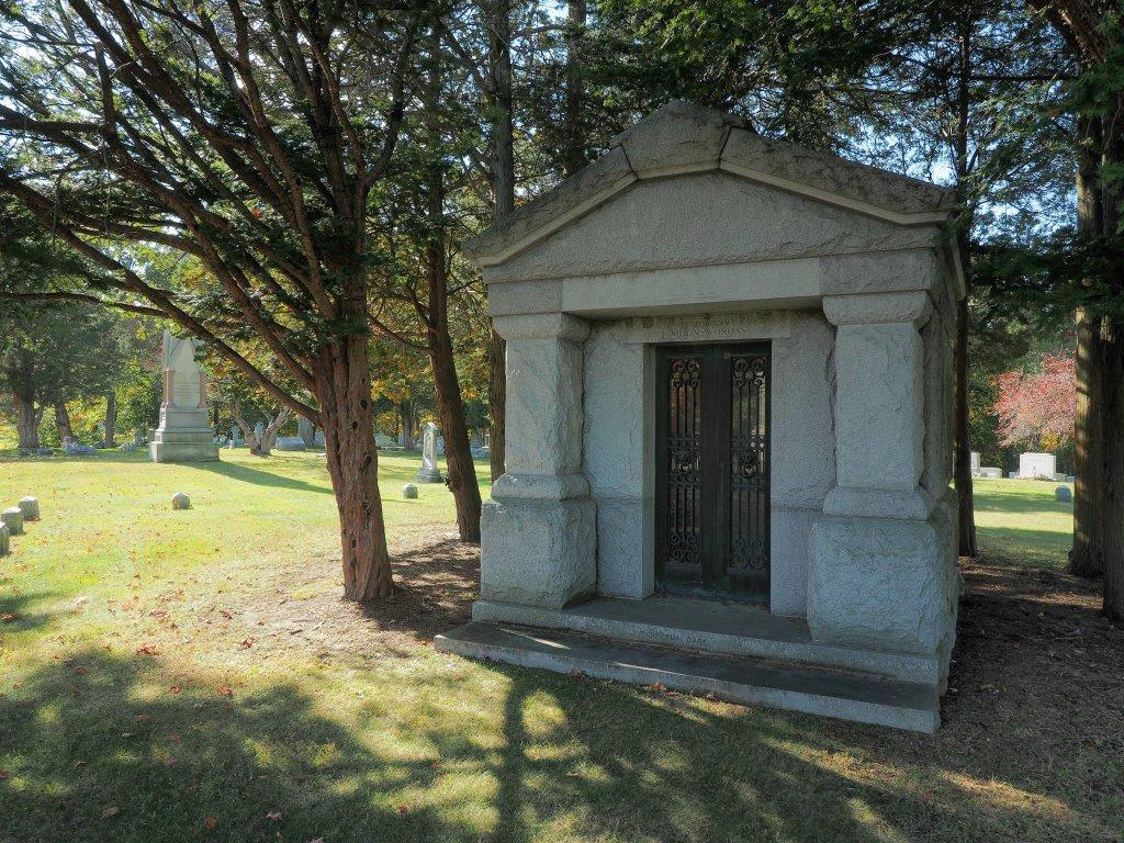 Oak Lawn Cemetery and Arboretum large above ground stone family mausoleum in a private setting with beautiful wooded backdrop
