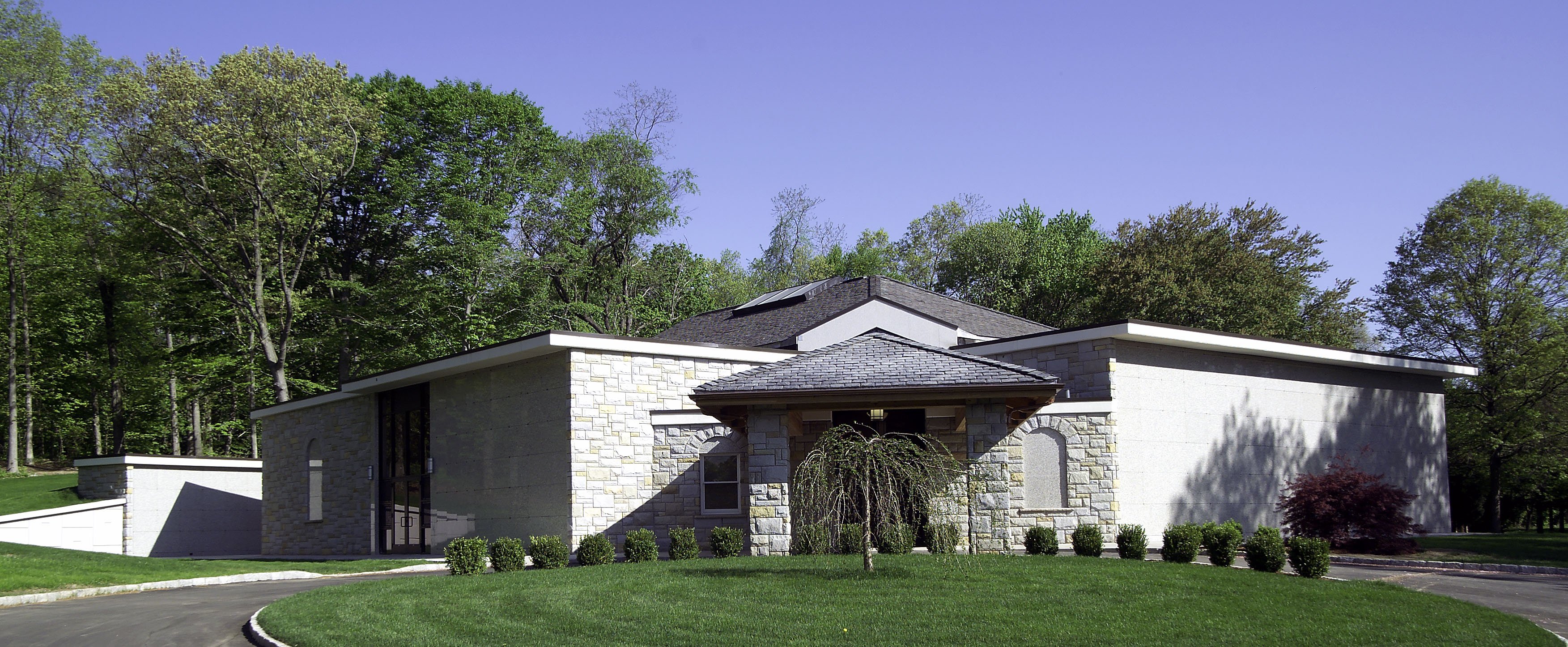 Oak Lawn Cemetery and Arboretum community mausoleum state of the art facility with manicured front grass area in wooded section of arboretum